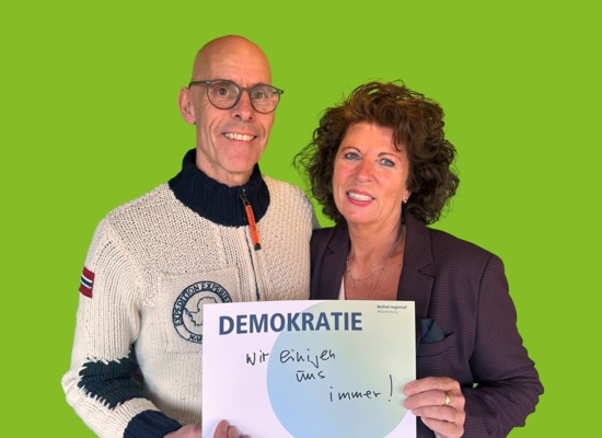 Mann und Frau mit Schild in der Hand Demokratie wir einigen uns immer!