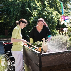 Zwei lächelnde Damen erledigen Gartenarbeit