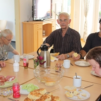 Menschen sitzen am Tisch und Essen gemeinsam in der Tagesgestaltung Paderborn von Bethel.regional
