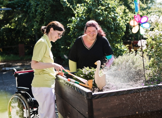 Zwei lächelnde Damen erledigen Gartenarbeit