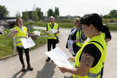 5 Menschen mit Karten in der Hand, die etwas planen.