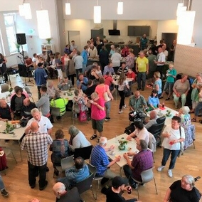 Gruppe von Menschen stehen oder sitzen und trinken Kaffee