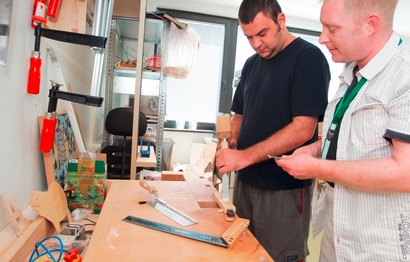 Zwei Männer arbeiten an einer Werkbank im Haus Billerbeckstraße in Witten, das für die Tagesgestaltung für Menschen mit psychischer Erkrankung zuständig ist
