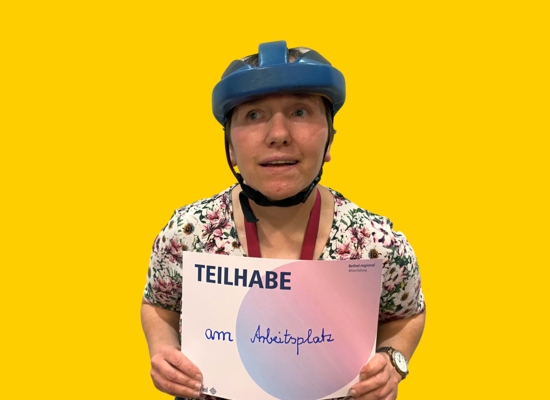 Frau mit Schild in der Hand Teilhabe am Arbeitsplatz.
