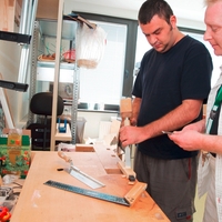 Zwei Männer arbeiten an einer Werkbank im Haus Billerbeckstraße in Witten, das für die Tagesgestaltung für Menschen mit psychischer Erkrankung zuständig ist
