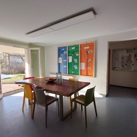 Foto: Großer Raum mit einem Tisch,  Stühle und offenen Türen zum Garten