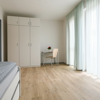 Großes Zimmer mit Bett, Schrank und Schreibtisch vom Haus an der Kirche in Ennepetal in Bethel.regional, in dem Menschen mit seelischen Erkrankungen leben