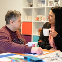 In Bethel Regional Haus Echeloh in Dortmund sitzen zwei Frauen nebeneinander an einem Tisch und trinken etwas zusammen aus Tassen