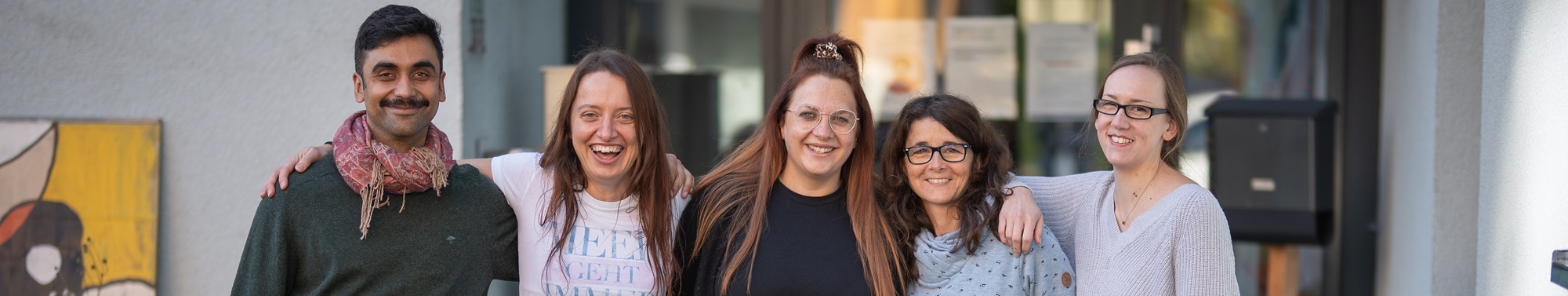 Zu sehen sind vier Frauen und ein Mann, die ihre Arme umeinander gelegt haben. Sie sind Bethel.regional-Mitarbeitende im Haus Breslaustraße in Dortmund.