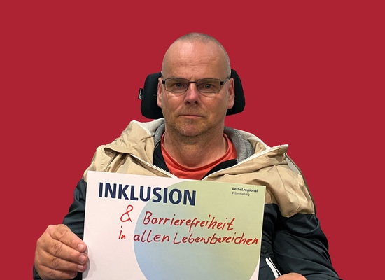 Mann mit Schild in der Hand Inklusion und Barrierefreiheit in allen Lebensbereichen.
