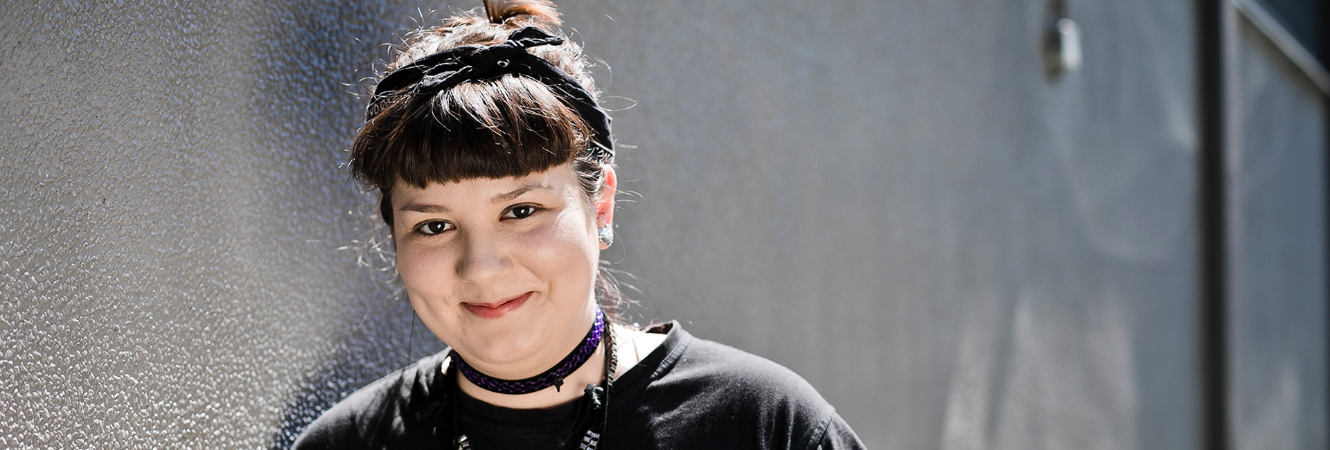 Junge Frau in schwarz angezogen lächelt