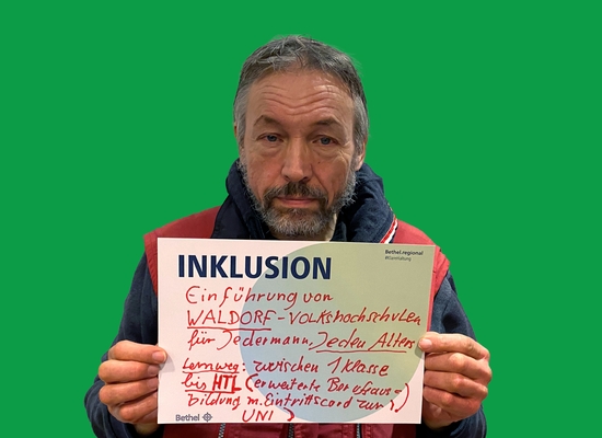 Mann mit Schild in der Hand Inklusion Einführung von WALDORF-Volkshochschulen für Jedermann, jeden Alters.