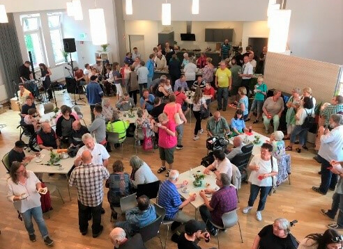 Gruppe von Menschen stehen oder sitzen und trinken Kaffee