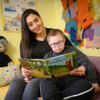 In Bethel Regional Haus am Funkturm in Dortmund Sitzen eine Frau lächelnd in die Kamera und ein Junge auf einem Sofa und halten ein Buch namens "Der Grüffelo" in den Händen