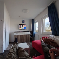 Foto: Personen liegen auf einer Couch und schauen fern