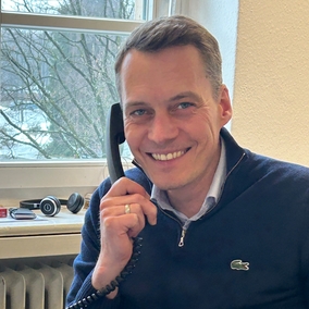 Christian Henning, Medizinproduktesicherheitsbeauftragter von Bethel.regional, am Telefon mit Kaffeebecher in der Hand