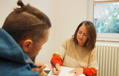 Eine Mitarbeiterin der Mobilen Mieterhilfe berät einen Nutzer.