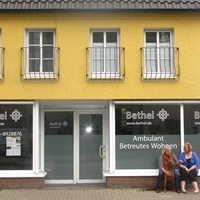 Zwei Frauen sitzen vor dem Eingang des Ambulant Betreuten Wohnen in Coesfeld von Bethel.regional, wo Menschen unterstützt werden, die bei der Tagesgestaltung Unterstützung brauchen.