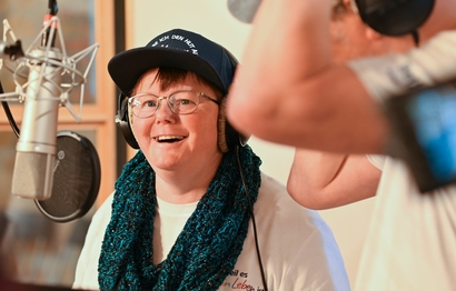 Zwei Personen bei der Gesangsaufnahme im Studio am Mikrofon