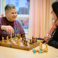 In Bethel Regional Haus Echeloh in Dortmund sitzen zwei Frauen lächelnd nebeneinander und spielen Schach zusammen