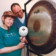 Zwei Personen bei der Musiktherapie mit einem Gong.